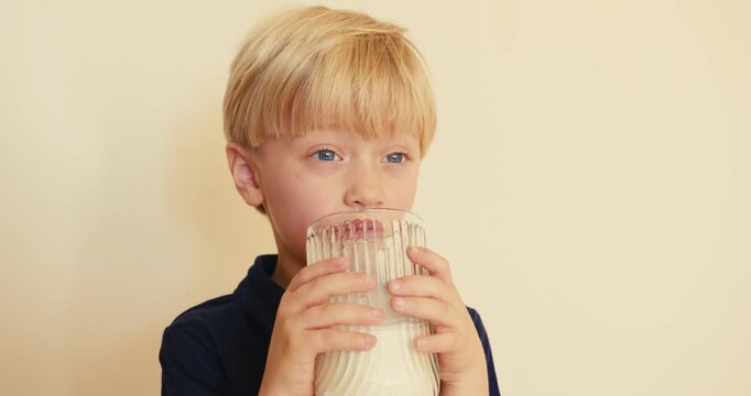 Little blond boy drinking milk and laughing