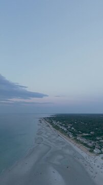 4K vertical video of Mayflower Beach on Cape Cod showing a calm ocean at low tide at sunset, Dennis, Massachusetts, MA, USA