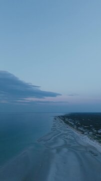 4K vertical video of Mayflower Beach on Cape Cod showing a calm ocean at low tide at sunset, Dennis, Massachusetts, MA, USA