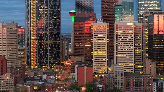 Panning drone view of illuminated Calgary Tower at dawn