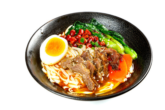 Delicious beef ramen noodle soup with egg and vegetables in black bowl - handmade Asian cuisine