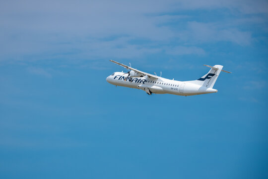 Riga, Latvia - July 06, 2026: Finnair ATR 72-500 aircraft flying against a clear blue sky, showcasing the airline's branding and design features