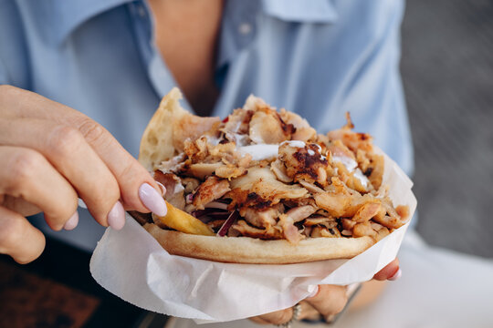 Hand Holding Chicken Shawarma Pita Sandwich With Fries and Garlic Sauce Street Food Lunch