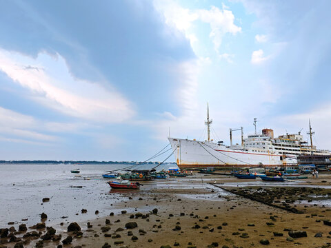 Anchored vessel and fishing boats at low tide in Zhanjiang, Guangdong, China