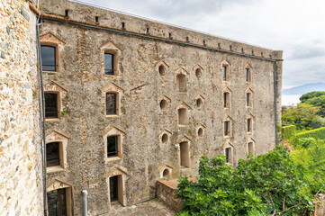 Fototapeta premium Interior view of the courtyard of the medieval fortress of Priamar in Savona, Liguria, Italy. Close-up of an ancient fortified courtyard with medieval walls.