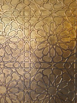 Islamic geometric carving ornament on antique golden brass metal surface detailed texture