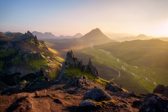 Hiker on lava spire at golden sunset, Laugavegur Iceland