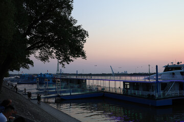 Fototapeta premium Sunset Riverboats Along the Songhua River Promenade