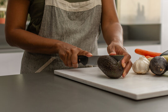 Close up of hands slicing fresh avocado for healthy meal preparation