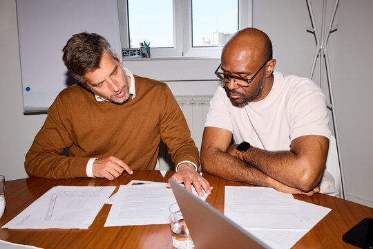 Men discuss paperwork together