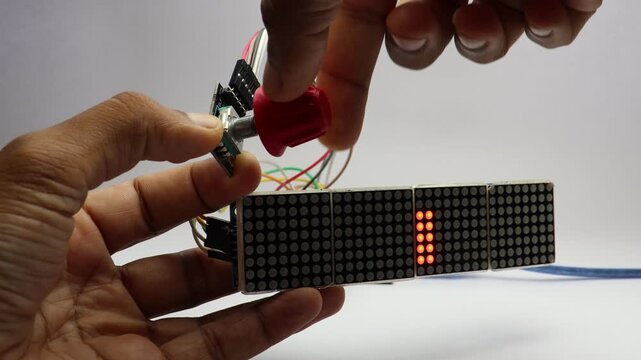 Red dot matrix display with patterns of dots moving with rotary encoder knob rotation showing analog to digital control