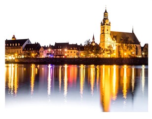 Fototapeta premium Reflections of historic building on calm water at dusk.