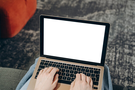 laptop mockup Person typing on a laptop with a blank white screen, suggesting remote work, online communication, writing and productivity in a casual home workspace or freelance