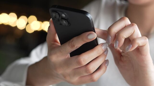 woman holds smart phone in her hands and scrolls through the news feed. Close up of hand uses mobile. point finger on screen, texting text message.