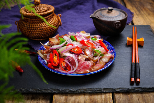 Spicy pork salad with onions and chili peppers on rustic plate