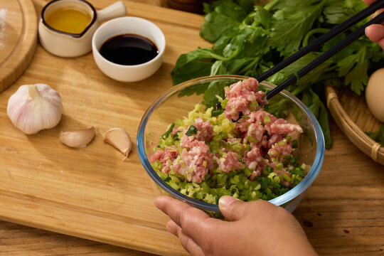 Mixing minced pork and vegetable dumpling filling with chopsticks