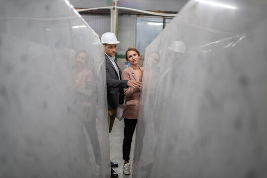 Man and woman examining marble slabs in warehouse