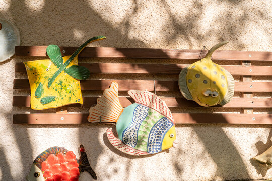Colorful Fish and Decorations on a Wall in a Sunny Location