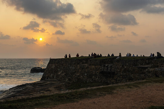 People gather on Galle Forte wall in Sri Lanka to watch the sunset