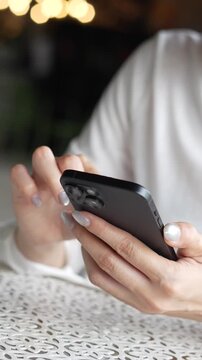 woman holds smart phone in her hands and scrolls through the news feed. Close up of hand uses mobile. point finger on screen, texting text message.