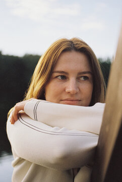 A woman wraps herself in a striped linen blanket outdoors