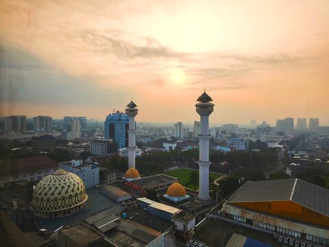 Bandung, Indonesia - July 09 2026: Aerial landscape view of the Bandung Square area against the background of the twin towers of the Bandung Grand Mosque at foggy sunrise.