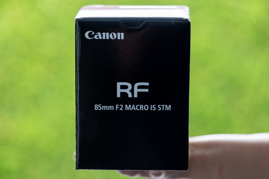 Hand holding canon rf 85mm f2 macro is stm lens box