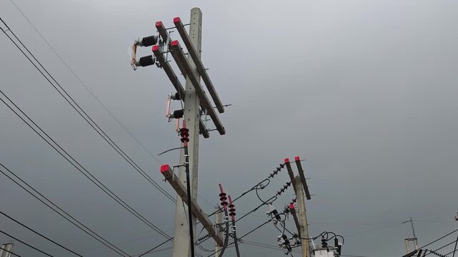 Panning right side view video of new high voltage disconnect switches and cable terminations on a concrete riser pole before electrical connection.