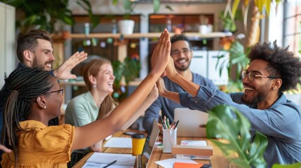 Obraz premium Coworkers celebrate a successful project completion by sharing a high five in a modern bright office.