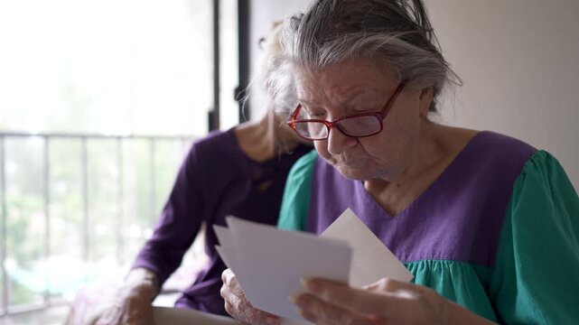 Mature daughter visits mother to share moments and memories together at senior care facility in the afternoon light.