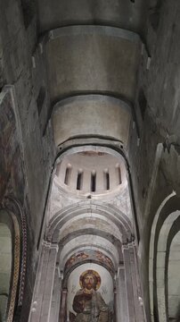 Low angle view of the stone interior of an Svetitskhoveli ancient christian church in Georgia, revealing a beautiful fresco of Jesus Christ on the altar apse