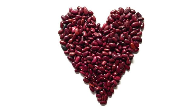 Studio shot of traditional raw dried red beans Phaseolus vulgaris arranged in a romantic heart shape isolated on white background from Guatemala.