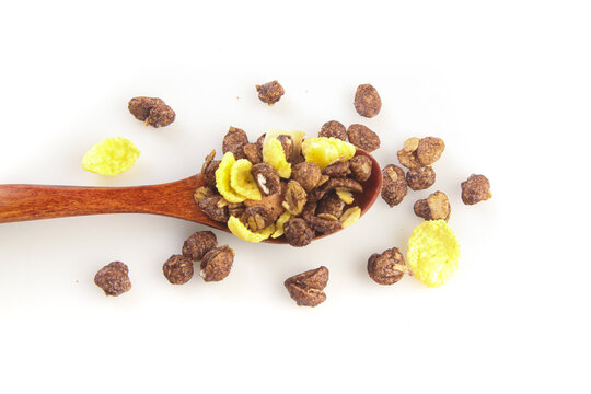 Chocolate cereal muesli with corn flakes on wooden spoon - healthy breakfast food studio photography