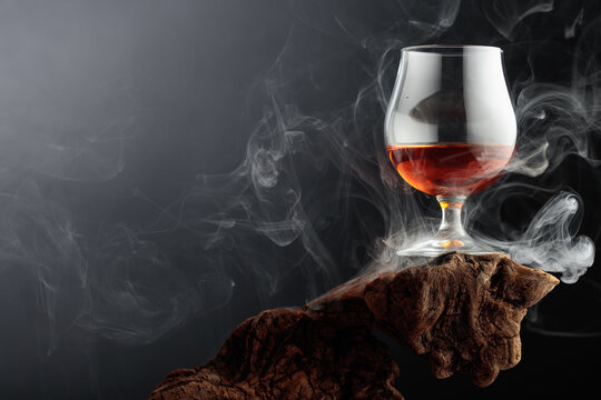 Smoked old-fashioned cocktail on weathered driftwood.