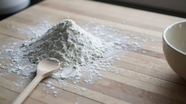 flour and rolling pin,Flour and rolling pin, wooden rolling pin dusted with fresh white flour, baking ingredients arranged on a rustic wooden surface, scattered flour, wheat grains, small bowl of flou