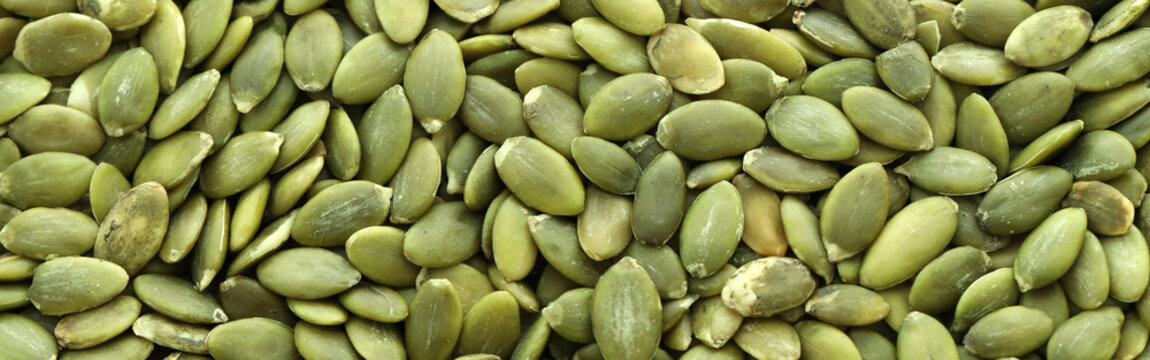 Detailed view on raw pumpkin seeds in big pile on table close up