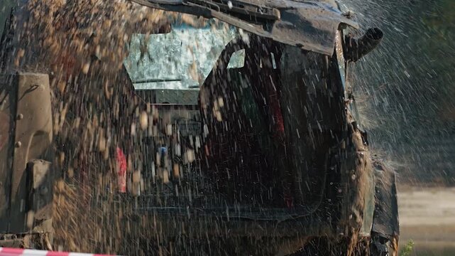 Mud racing. A modified SUV, covered in mud, is sprayed with water after the race. Extreme sports concept