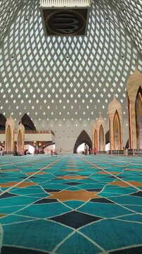Bandung, Indonesia - July 08, 2026: Low angle view of the interior of the Al-Jabbar Grand Mosque showing the expansive distinctive patterned blue carpet.
