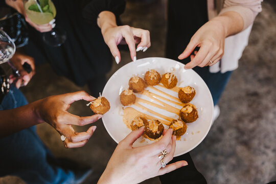 Hands Reaching for Appetizer