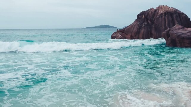 Amazing tropical beach Anse Patates with palm trees and granite boulders on La Digue Island, Seychelles