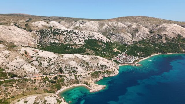 Drone view of coastline on Krk island in Croatia with turquoise Adriatic Sea, rocky hills and secluded beaches. Mediterranean summer vacation and coastal nature concept