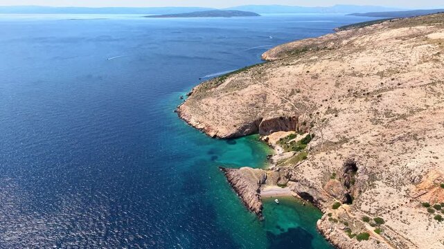 Drone view of coastline on Krk island in Croatia with turquoise Adriatic Sea, rocky hills and secluded beaches. Mediterranean summer vacation and coastal nature concept