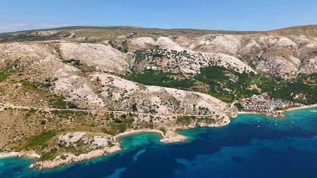 Drone view of a secluded turquoise bay surrounded by dramatic limestone hills and rugged coastline near Stara Ba&scaron;ka on Krk Island, Croatia