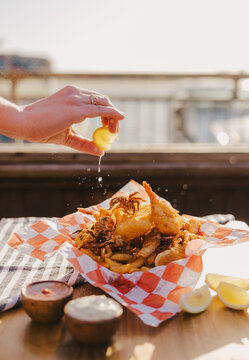 Hand Squeezing Lemon on Seafood Sampler