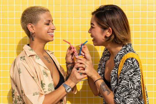 Beautiful multiethnic lesbian couple of lovers dating outdoors - LGBT people bonding and spending time together, concepts about LGBTQ community, diversity, love and lifestyle
