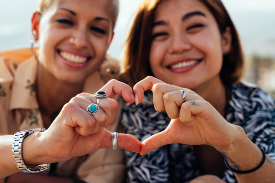 Beautiful multiethnic lesbian couple of lovers dating outdoors - LGBT people bonding and spending time together, concepts about LGBTQ community, diversity, love and lifestyle
