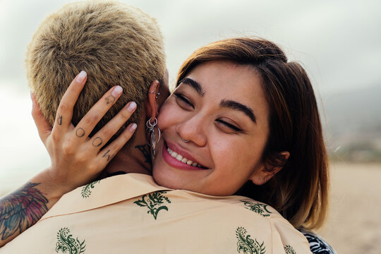 Beautiful multiethnic lesbian couple of lovers dating outdoors - LGBT people bonding and spending time together, concepts about LGBTQ community, diversity, love and lifestyle
