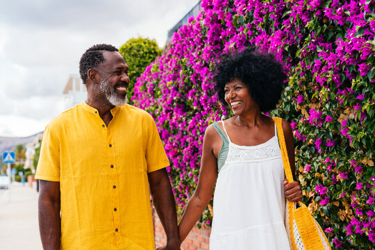 Beautiful mature black couple of lovers dating at the seaside - Married african middle-aged couple bonding and having fun outdoors, concepts about relationship, lifestyle and quality of life