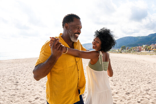 Beautiful mature black couple of lovers dating at the seaside - Married african middle-aged couple bonding and having fun outdoors, concepts about relationship, lifestyle and quality of life