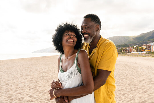 Beautiful mature black couple of lovers dating at the seaside - Married african middle-aged couple bonding and having fun outdoors, concepts about relationship, lifestyle and quality of life